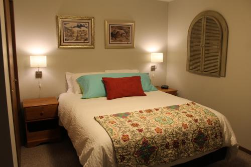 賈斯珀的住宿－落基山脈寶石酒店，一间卧室配有一张床、两盏灯和一个窗户。
