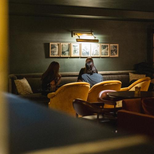 two women sitting on a couch in a waiting room at Le Fitz Roy, a Beaumier hotel in Val Thorens