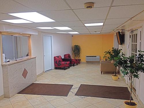 an office lobby with chairs and a tv on the ceiling at Tappan Zee Hotel in West Nyack