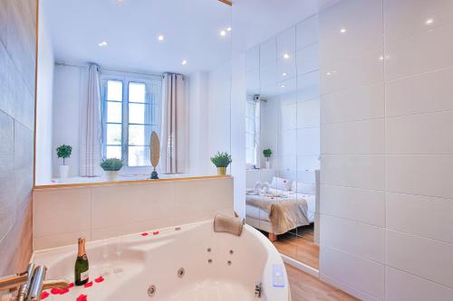 - une salle de bains blanche avec baignoire et une chambre dans l'établissement Escapade en Amoureux T2 luxueux, Love Room avec balnéo, 60m gare - hypercentre - La Porte Bleue 4, à Toulon