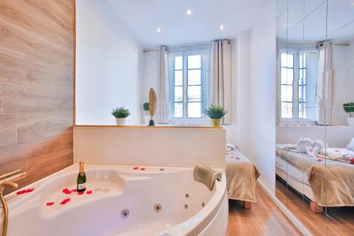 La grande salle de bains est pourvue d'une baignoire et d'un lit. dans l'établissement Escapade en Amoureux T2 luxueux, Love Room avec balnéo, 60m gare - hypercentre - La Porte Bleue 4, à Toulon