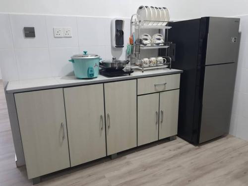 a kitchen with white cabinets and a black refrigerator at 75 pangkor ocean in Pangkor