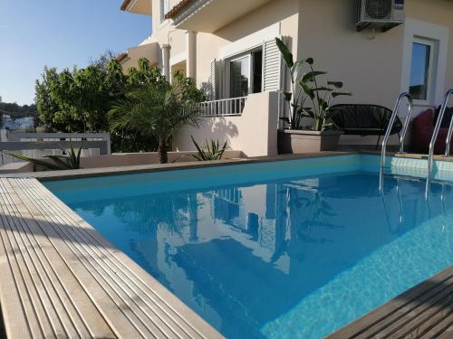 a swimming pool in front of a house at Vivenda Geminada com piscina a 10 minutos a pé da praia, by QoZzy in Portimão