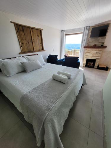 ein Schlafzimmer mit einem großen Bett mit zwei Handtüchern darauf in der Unterkunft Chalé Colina in Venda Nova do Imigrante