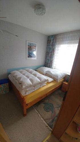 a bed in a room with a window at Ferienwohnung Esener Bär in Esens