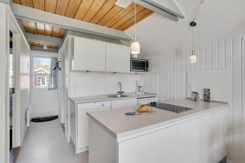 a kitchen with white cabinets and a counter top at Lalandia Rødby in Rødby