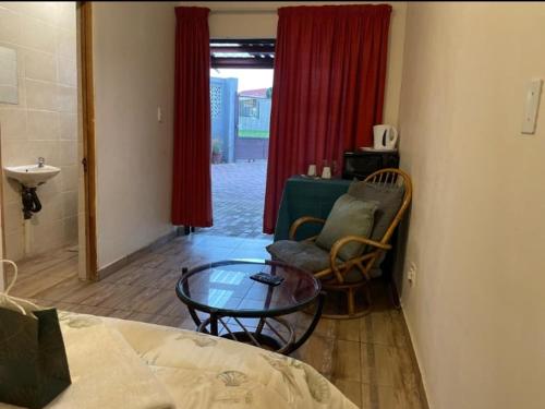 a room with a bed and a table and a chair at Cheryl's Fortress in Johannesburg