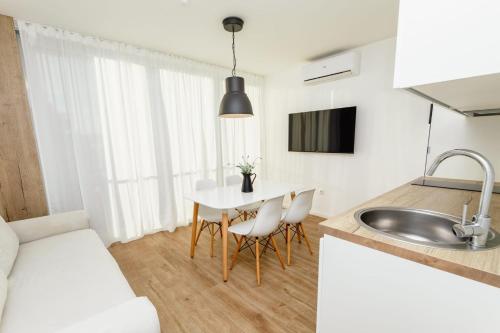 een keuken en eetkamer met een tafel en een spoelbak bij Olive Tree Apartments in Vodice