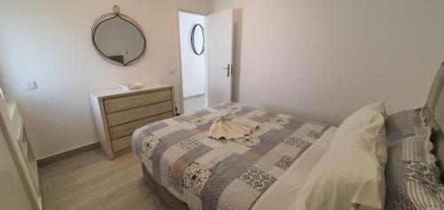Schlafzimmer mit einem Bett, einer Kommode und einem Spiegel in der Unterkunft ACR Holiday Apartment in Quarteira