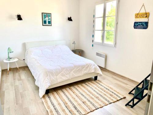 um quarto branco com uma cama e um tapete em Villa piscine a La Flotte en Re em La Flotte