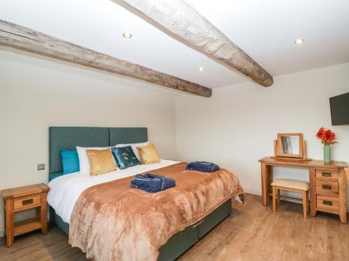 a bedroom with a large bed and a table at Palace Farmhouse in Hereford