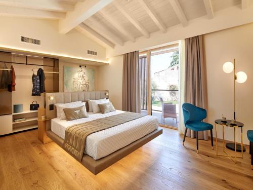 una camera con un letto e una grande finestra di Relais Forte Benedek Wine & SPA - Adults Only a Pastrengo