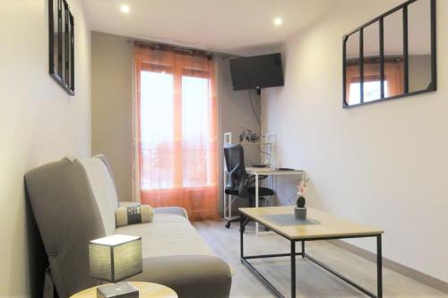 Le Belvédère Dernier étage avec terrasse WIFI FIBRE في تارْب: غرفة معيشة مع أريكة وطاولة