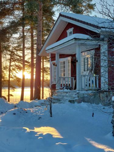 a small red and white house in the snow at Rysseli in Kiuruvesi