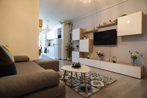 a living room with a couch and a tv at Azure Home in Cluj-Napoca