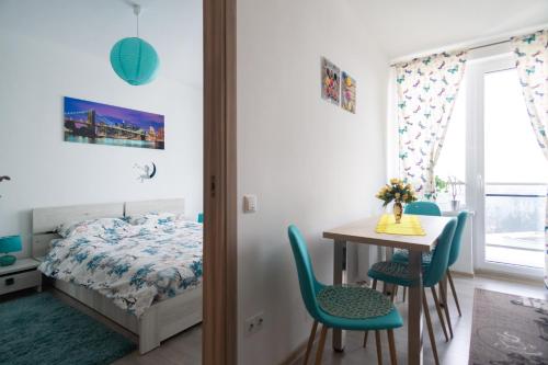 1 dormitorio con 1 cama, mesa y sillas en Azure Home, en Cluj-Napoca