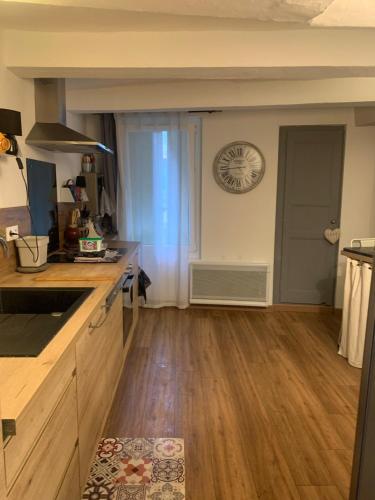 Il comprend une cuisine dotée de parquet et d'une horloge murale. dans l'établissement La Petite Adresse de Rose Maison de vacances Entrée autonome, à Le Poujol-sur-Orb