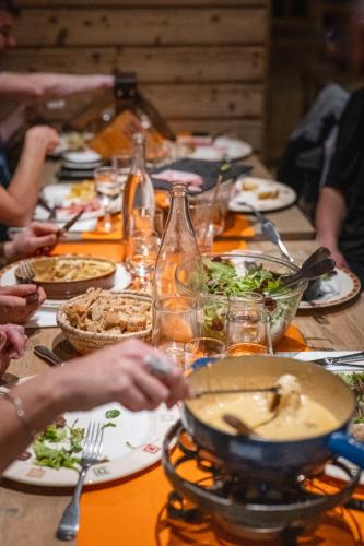 a group of people sitting around a table eating food at Le Val Thorens, a Beaumier hotel in Val Thorens