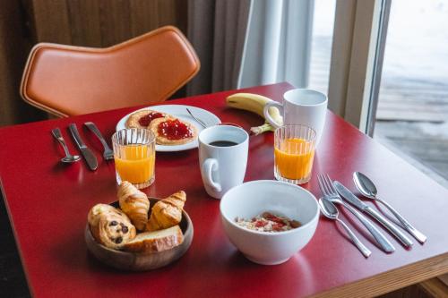 a red table with breakfast foods and drinks on it at Le Val Thorens, a Beaumier hotel in Val Thorens