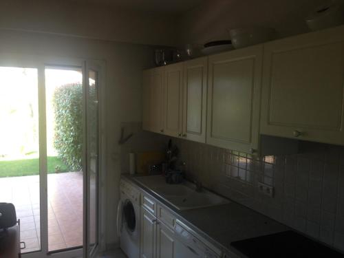 une cuisine avec un évier et une machine à laver dans l'établissement Villa Royal Mougins Golf Club, à Mougins