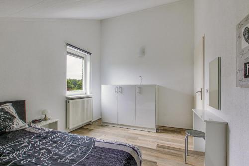 a white bedroom with a bed and a window at Big Family villa 12p big garden with bathtub and jacuzzi in Zeewolde