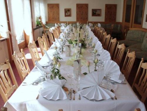 a long table with white tablecloths and flowers on it at Hotel Simonshof in Wolfsburg