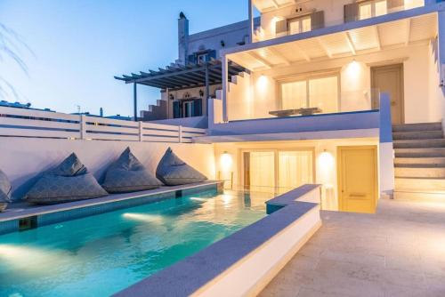 a house with a swimming pool in front of a building at Dream House "B" in Tinos Town