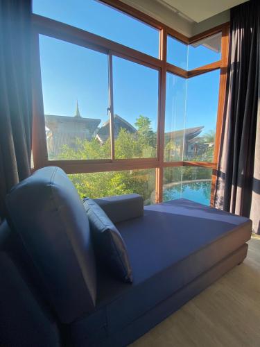 a bed in a room with a large window at Phurua Sanctuary Resort and Spa in Phu Rua