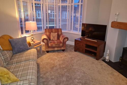 a living room with a couch and a tv and a chair at Wishbone House in Bridlington