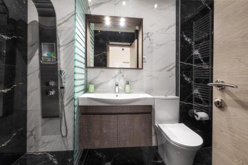 a bathroom with a sink and a toilet and a mirror at Newly built detached house with parking in Larisa