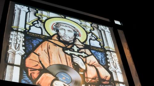 a stained glass window of a man holding a cd at The Funky Monk in Durham