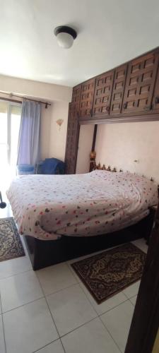 een slaapkamer met een bed met een houten hoofdeinde bij EDIFICIO PAOLA V CALLE PINTOR SOROLLA 18, VERDIEP 5, deur 3 in Calpe