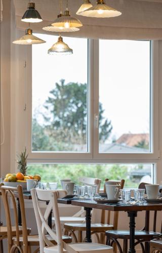 a dining room table with chairs and a window at Hôtel Maison Lacassagne Lyon in Lyon