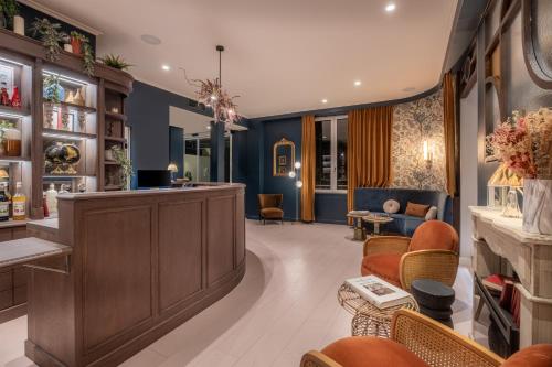un salon avec une salle d'attente avec des chaises et un bar dans l'établissement Hôtel Maison Lacassagne Lyon, à Lyon