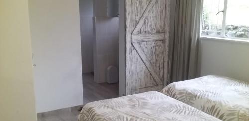 a bedroom with a bed and a wooden door at Bergview Chalet, Cathkin in Bergview