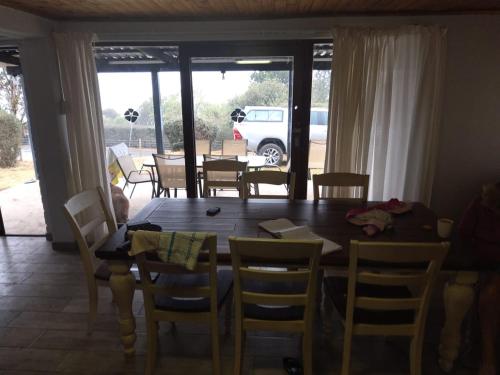 uma sala de jantar com uma mesa de madeira e cadeiras em Bergview Chalet, Cathkin em Bergview
