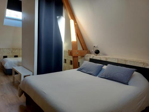 1 dormitorio con 1 cama con 2 almohadas azules en Gîte Saumur Le Pigeonnier, Calme et Cosy, en Épieds