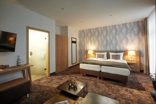 ヴィリンゲンにあるWILLINO Privathotelのベッドルーム(大型ベッド1台付)、リビングルームが備わります。
