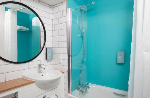 a bathroom with a sink and a glass shower at The Bay Horse Hotel in Haydock
