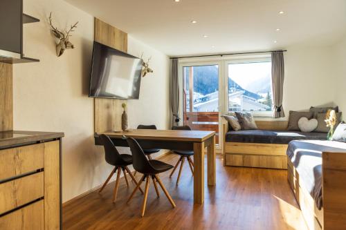uma sala de estar com uma mesa e um sofá em Apartments Mooshof em Neustift im Stubaital
