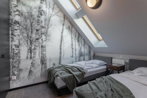 a bedroom with two beds and a forest mural at Green Park Resort C14- z dostępem do basenu, sauny, jacuzzi, siłowni in Szklarska Poręba