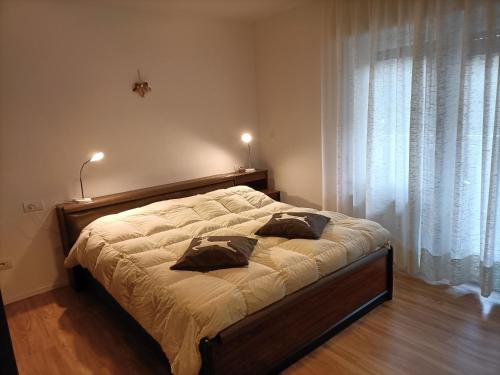 a bed with two pillows on it in a bedroom at Appartamenti Primiero in Fiera di Primiero