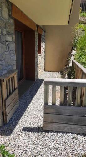 a porch of a building with a wooden bench at T2 cabine 6 pers au pied des pistes in Orcières