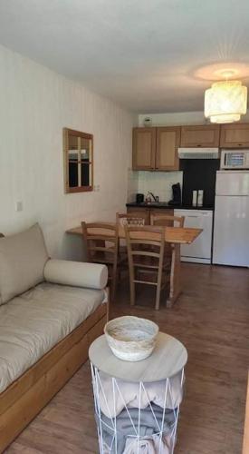 un salon et une cuisine avec un canapé et une table dans l'établissement Appart 6pers pieds des pistes avec piscine, à Orcières