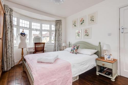 a bedroom with a bed and a chair and windows at Orchard - 3 Bedroom House Headington & parking & garden in Oxford