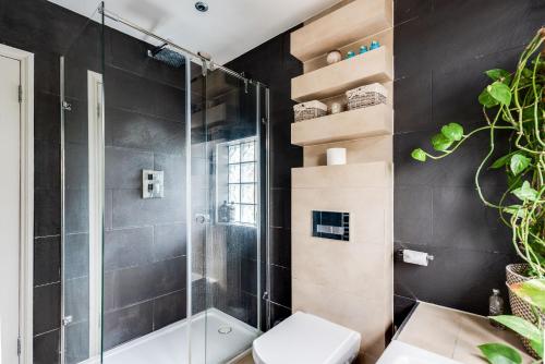 a bathroom with a shower and a toilet at Orchard - 3 Bedroom House Headington & parking & garden in Oxford