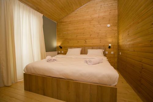 una camera con un grande letto e una parete in legno di Mestia Villas a Mestia