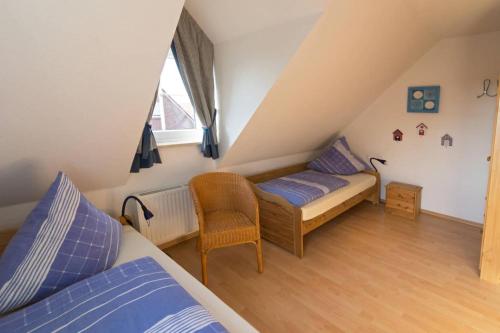 Un dormitorio abuhardillado con dos camas y una ventana. en Nordseemuschel, en Norddeich