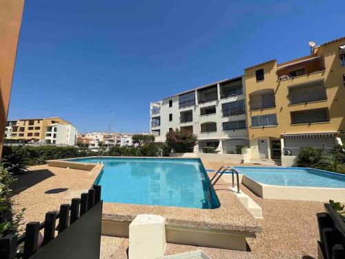 une piscine en face d'un bâtiment dans l'établissement CAP'NOMAD Studio Côté Mer - balcon - piscine - parking, au Cap d'Agde
