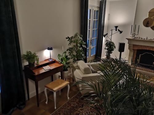 a living room with a couch and a table with plants at Maison et Florescence in Nuits-Saint-Georges